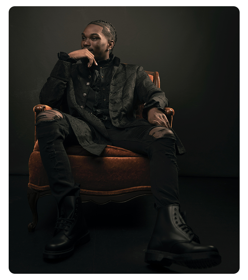 A young man sitting on a chair in fashionable clothes and shoes