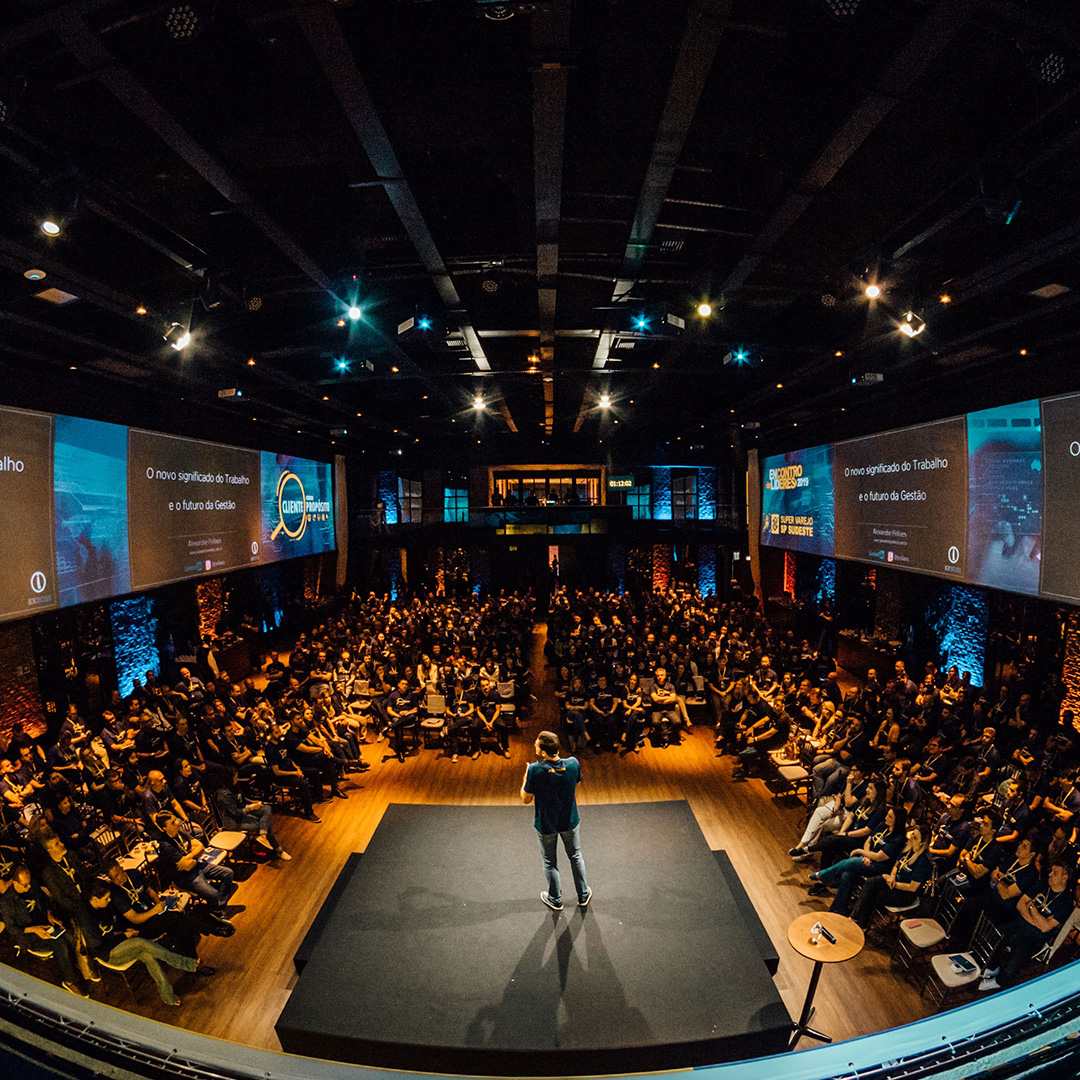 A speaker on a stage at a large conference